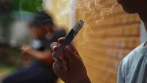 a guy is vaping outside