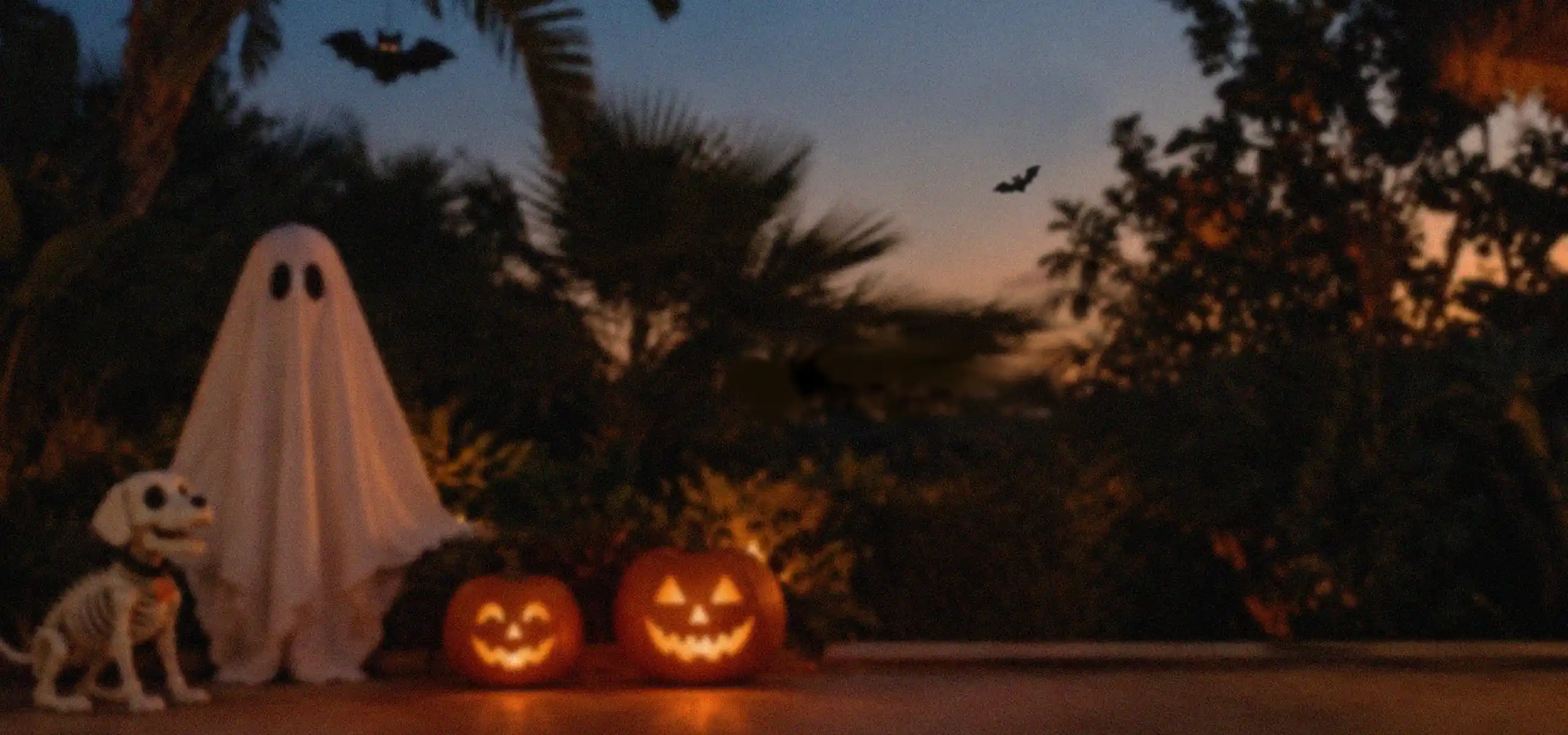 MYVAPOR Halloween scene with a friendly ghost, skeleton dog and glowing jack-o'-lanterns in a garden at dusk